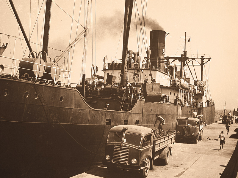 Immagine storica che mostra il carico della marce da una nave nel porto di piombino