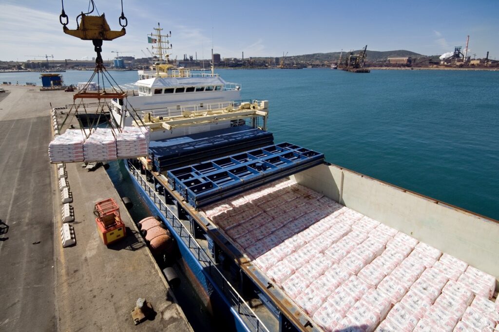 Foto che mostra le operazioni di carico da una grande nave cargo nel porto di
